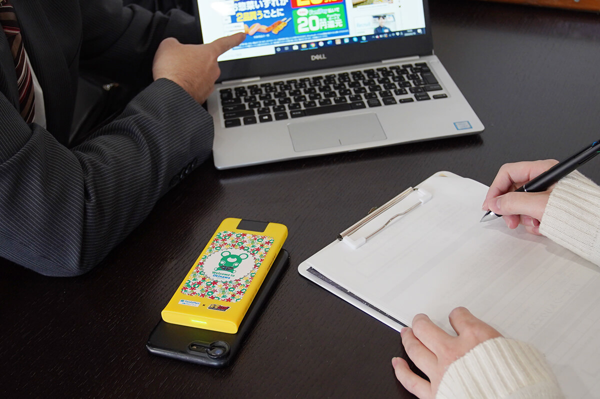 ノートパソコンを指差す男とメモをとる取引先の女性